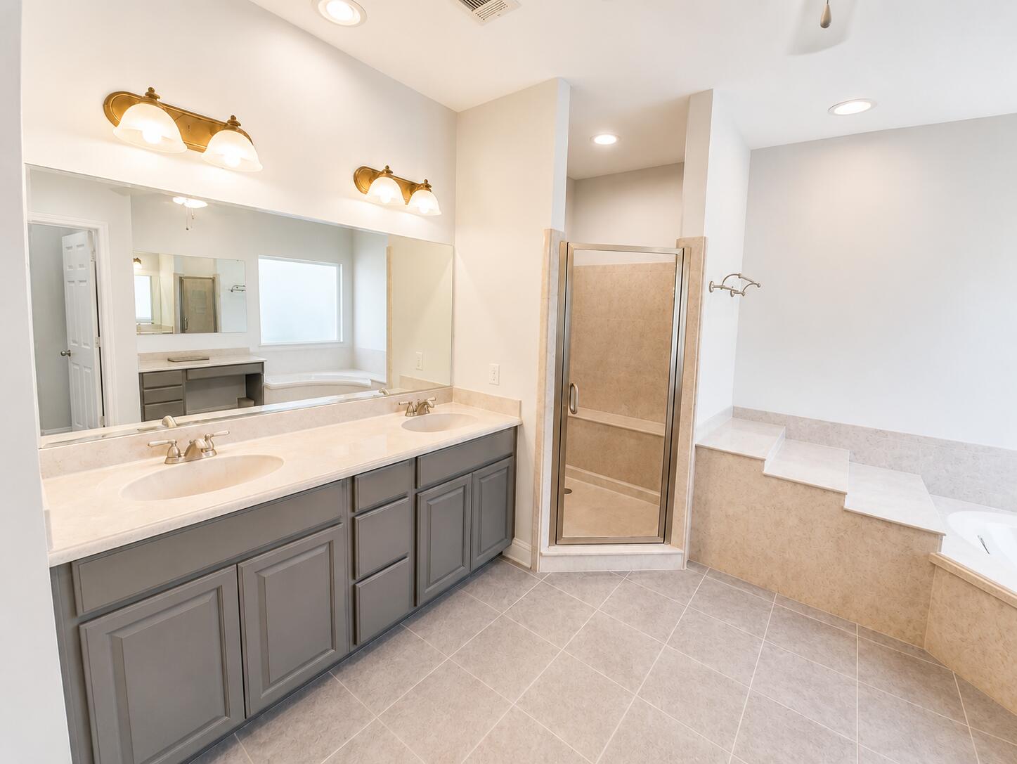 147 Dover Lane Freeport, FL 32439 - Photo 16 of 27 a bathroom with a double vanity sink a large mirror and a bathtub