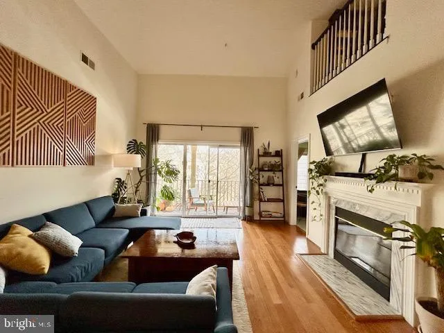 a view of an empty room with wooden floor and a fireplace