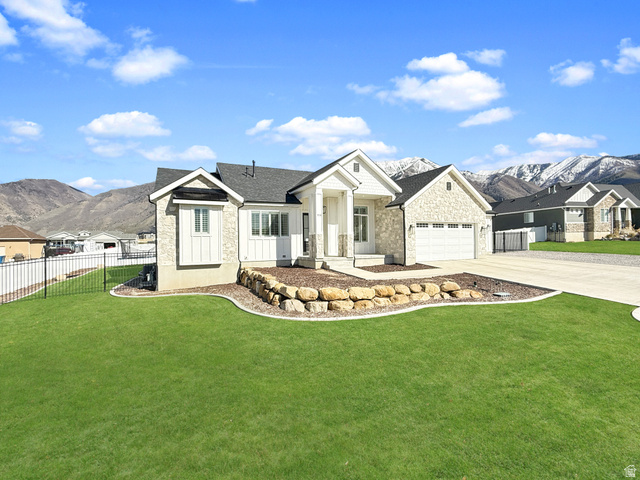 916 Rocky Mountain Way Elk Ridge, UT 84651 - Photo 3 of 54 View of front of home with a mountain view, stone siding, a garage, and concrete driveway