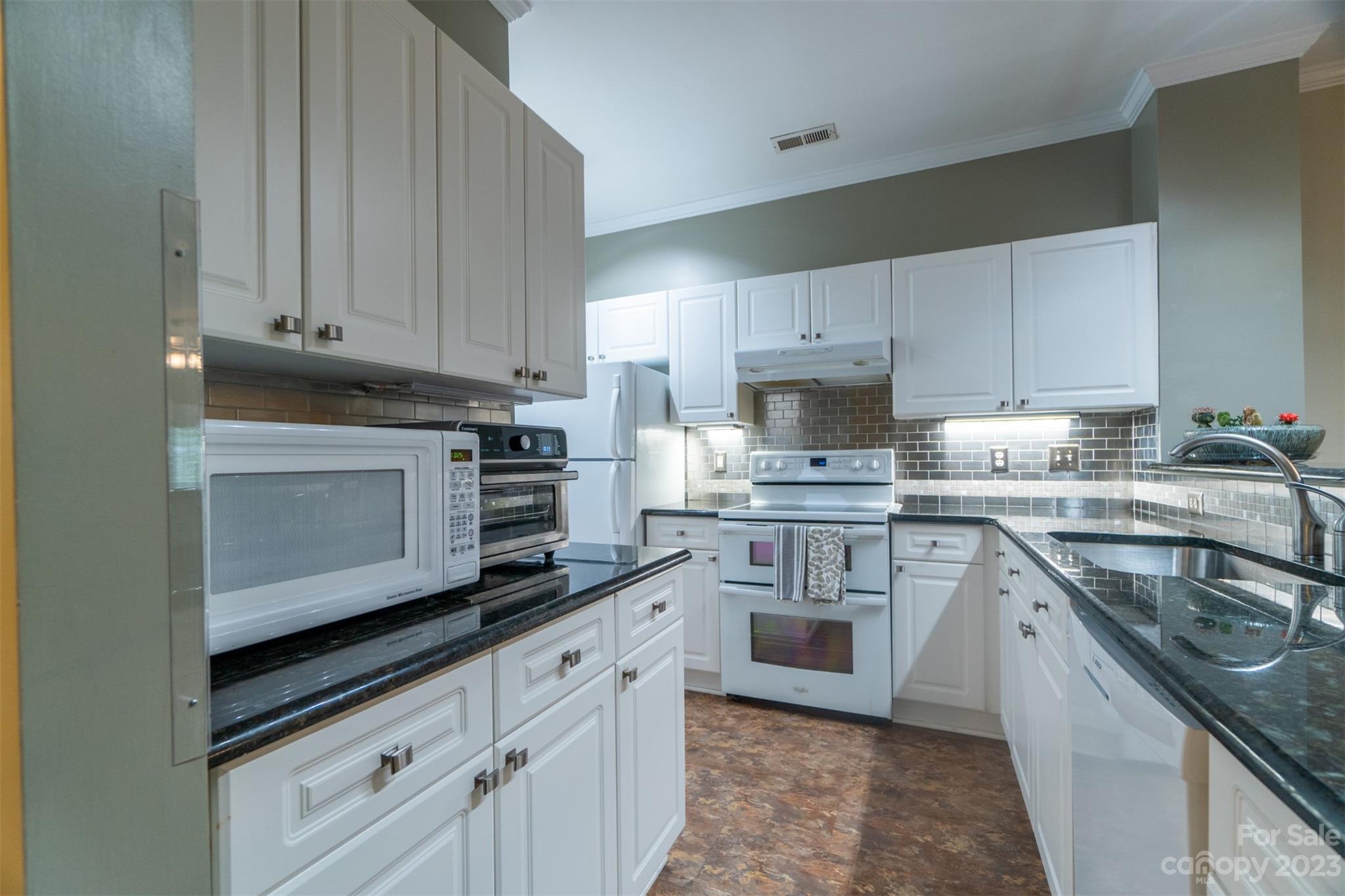 737 Peninsula Drive Davidson, NC 28036 - Photo 2 of 34 a kitchen with granite countertop white cabinets and stainless steel appliances