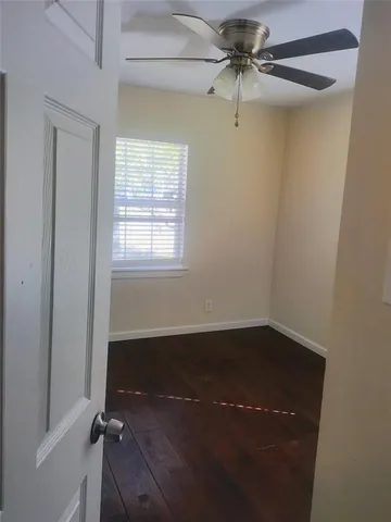 an empty room with a window and a fan