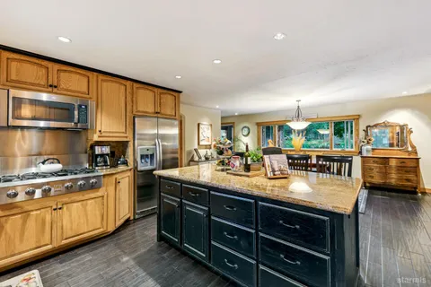 a kitchen with stainless steel appliances granite countertop a sink stove and wooden cabinets
