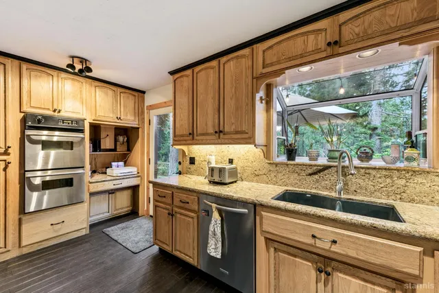 a kitchen with stainless steel appliances granite countertop a stove and a sink