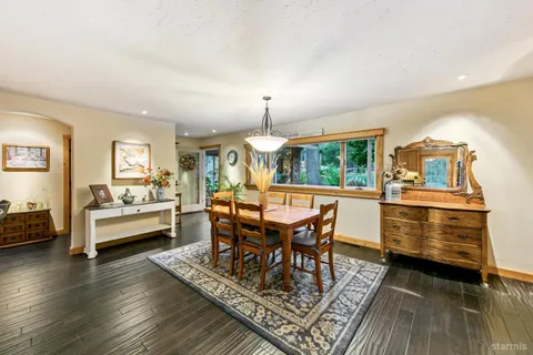a dining room with furniture wooden floor a rug and a chandelier