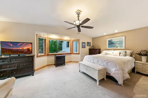 a spacious bedroom with a bed and a flat screen tv