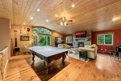 a living room with furniture a fireplace and a open kitchen view