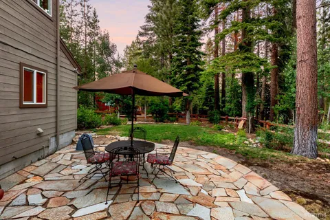 a view of a patio with table and chairs under an umbrella