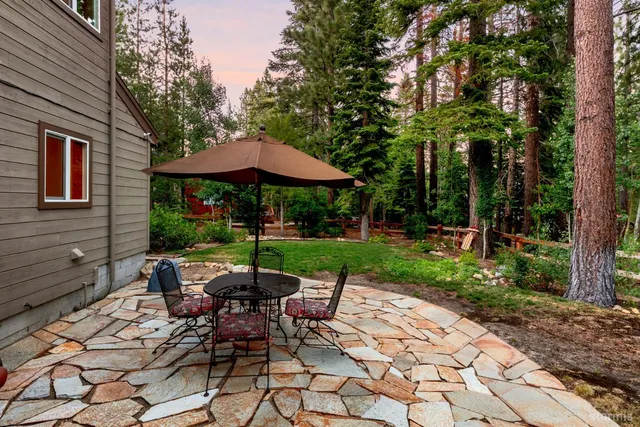 a view of a patio with table and chairs under an umbrella