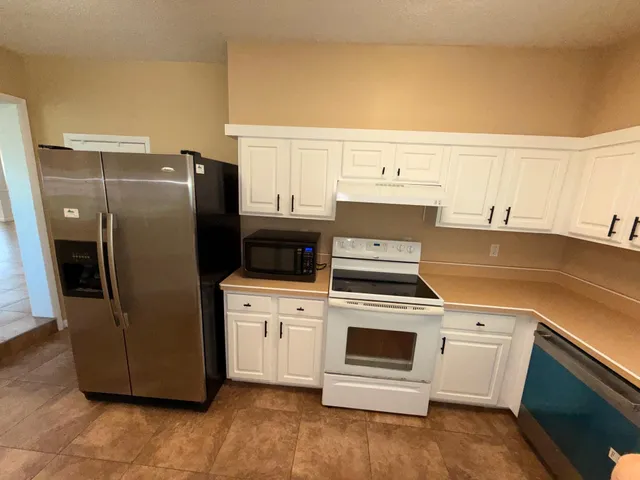 a kitchen with granite countertop white cabinets and sink