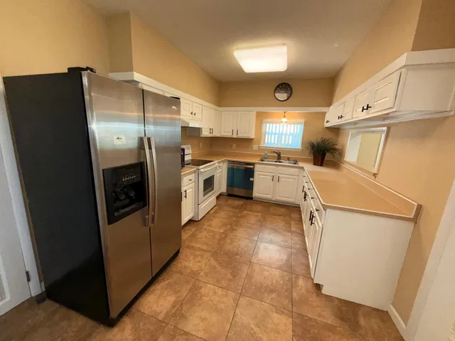 a kitchen with white cabinets and white appliances