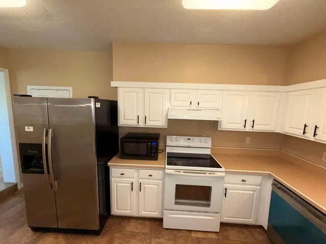 a kitchen with a refrigerator and a stove