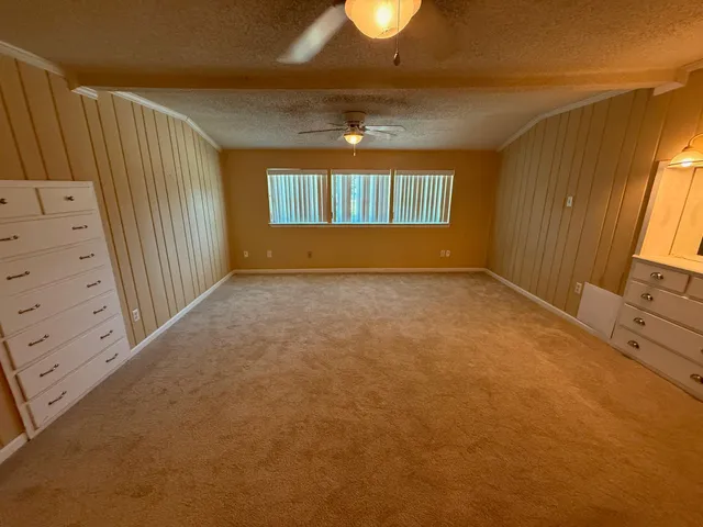 a view of a patio with table and chairs under an umbrella with a small yard