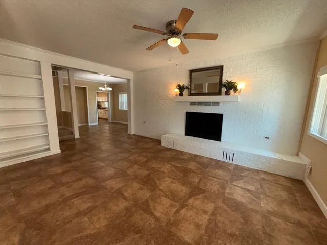 an empty room with windows and fireplace