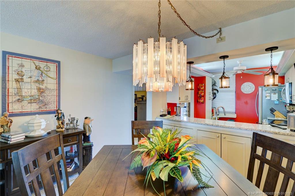 1950 Southwest Palm City Road, Unit 5306 Stuart, FL 34994 - Photo 11 of 55 a dining room filled with lots of furniture and a chandelier