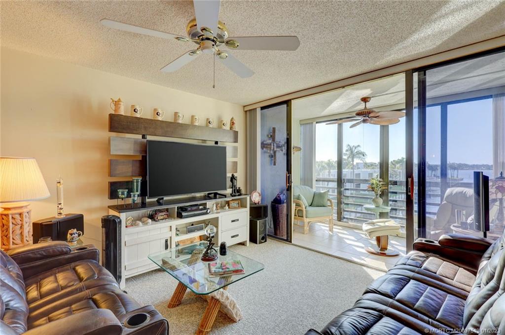 1950 Southwest Palm City Road, Unit 5306 Stuart, FL 34994 - Photo 13 of 55 a living room with furniture and a flat screen tv