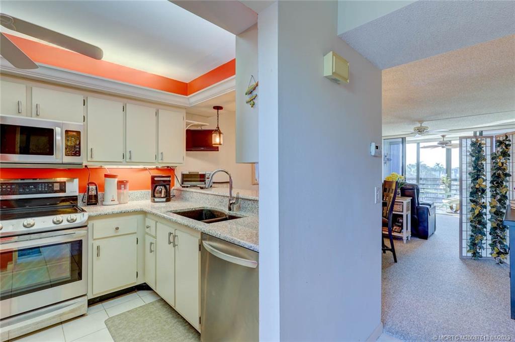 1950 Southwest Palm City Road, Unit 5306 Stuart, FL 34994 - Photo 17 of 55 a kitchen with stainless steel appliances granite countertop a stove top oven a sink and dishwasher