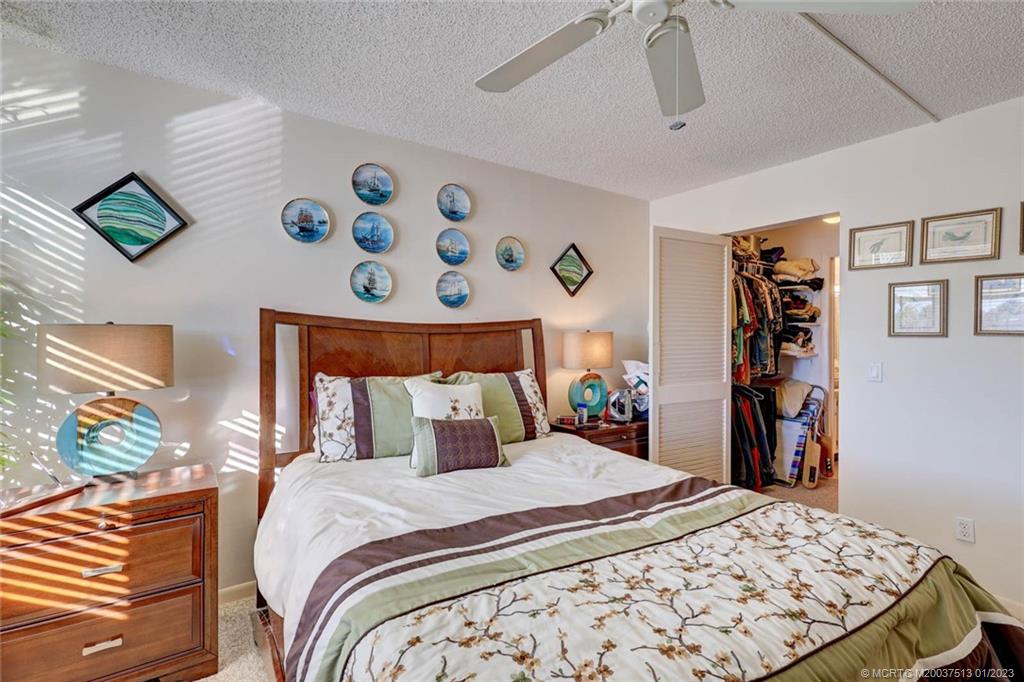 1950 Southwest Palm City Road, Unit 5306 Stuart, FL 34994 - Photo 22 of 55 a bedroom with a large bed and a bookshelf