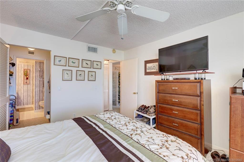 1950 Southwest Palm City Road, Unit 5306 Stuart, FL 34994 - Photo 23 of 55 a bedroom with a bed and a flat screen tv