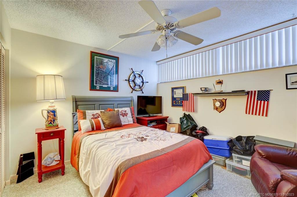 1950 Southwest Palm City Road, Unit 5306 Stuart, FL 34994 - Photo 25 of 55 a bedroom with a bed and a chandelier