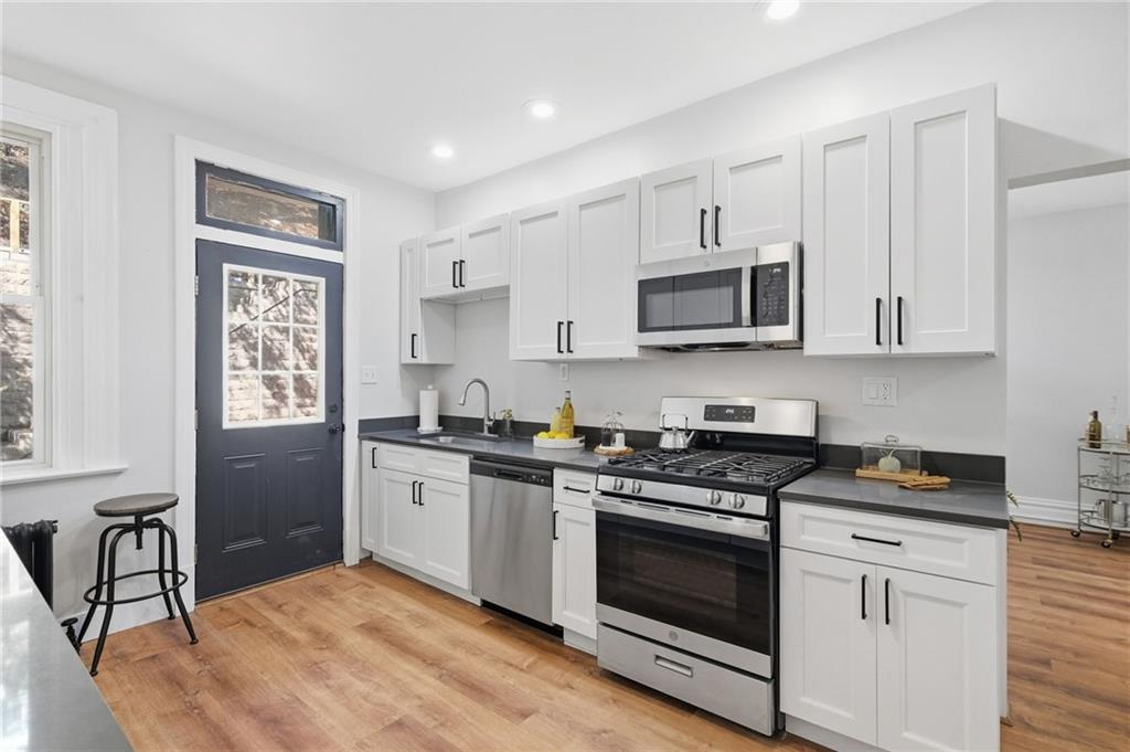 848 Grand Avenue Pittsburgh, PA 15212 - Photo 14 of 33 a kitchen with granite countertop a stove a sink and a microwave
