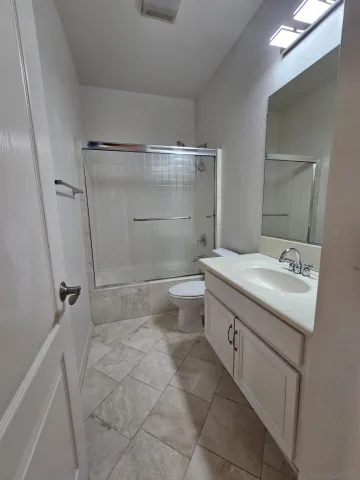 a bathroom with a granite countertop sink toilet and shower