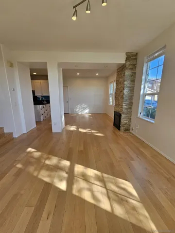 a view of a big room with wooden floor and windows