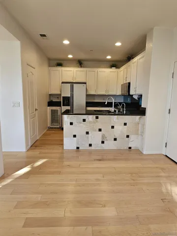a view of kitchen with stainless steel appliances kitchen island sink and refrigerator