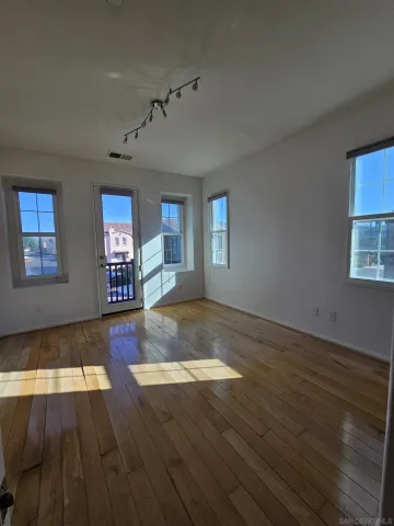 a view of a livingroom with wooden floor and a window