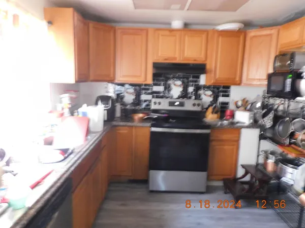 a kitchen with stainless steel appliances granite countertop a stove a sink and a refrigerator