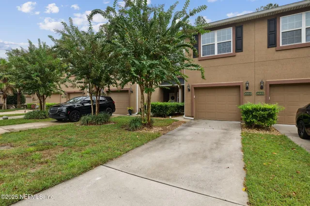 a front view of a house with a garden and trees