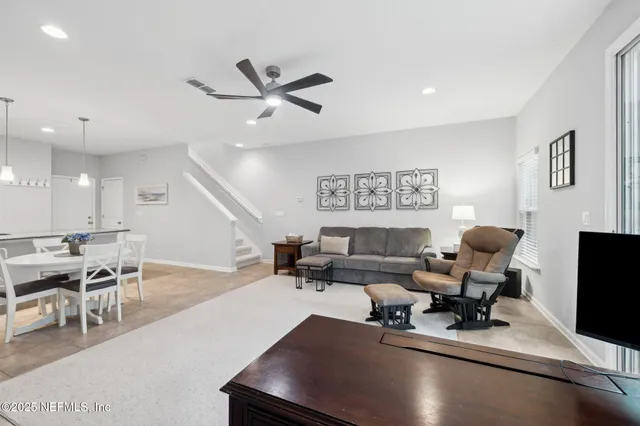 a living room with furniture and a flat screen tv with kitchen view