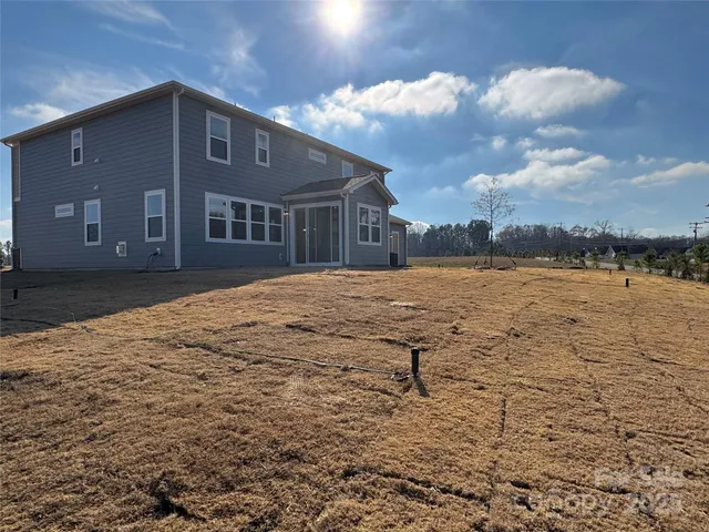 a large kitchen with a center island wooden floor stainless steel appliances and a window
