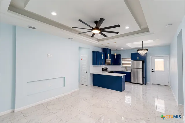 a large kitchen with a refrigerator and a stove top oven