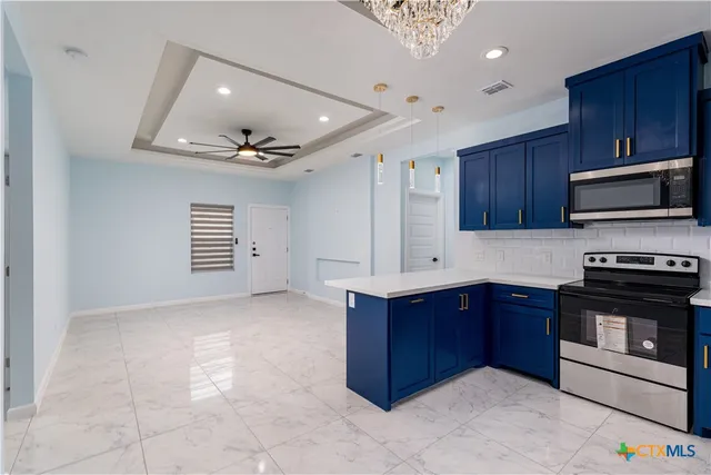 a kitchen with stainless steel appliances granite countertop a stove and a microwave with wooden cabinets