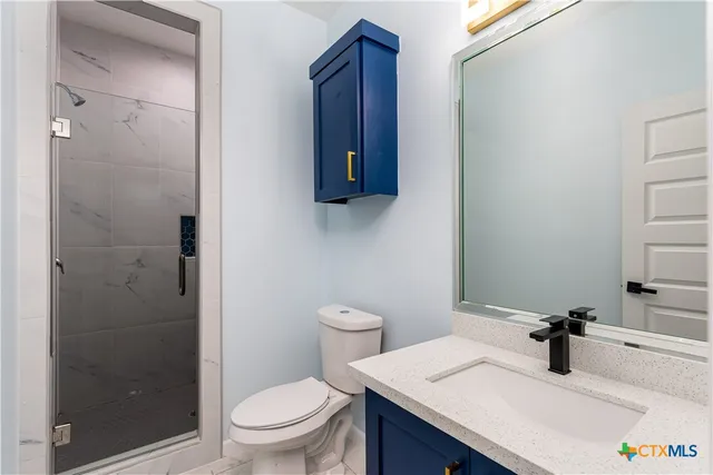a bathroom with a toilet a sink and mirror
