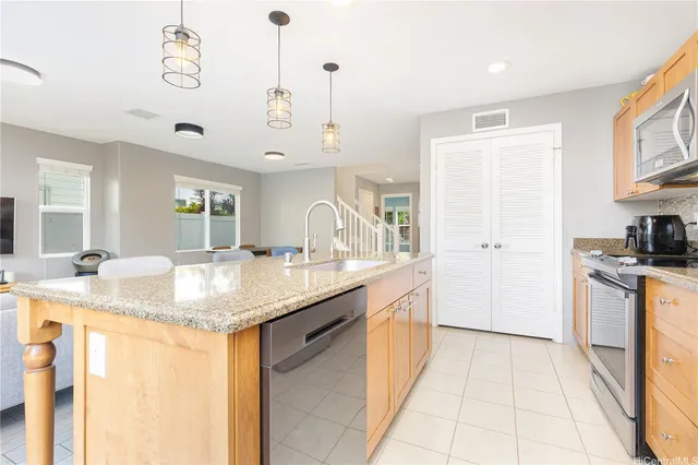 a kitchen with stainless steel appliances granite countertop a sink and dishwasher with white cabinets