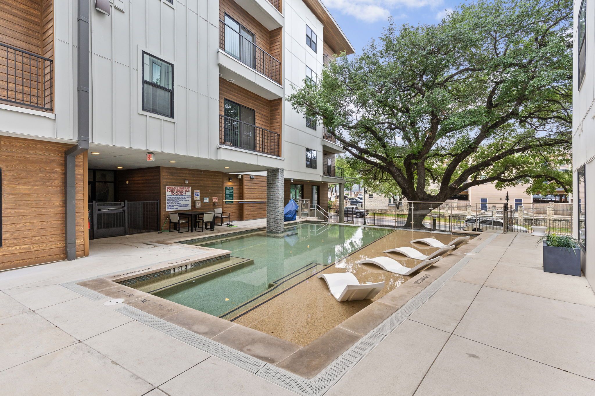 2500 Longview Street, Unit 507 Austin, TX 78705 - Photo 33 of 37 An inviting community pool with lounge seating offers refreshing relaxation against a backdrop of modern architecture.