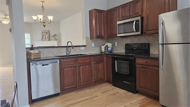 a kitchen with stainless steel appliances granite countertop a refrigerator stove and sink