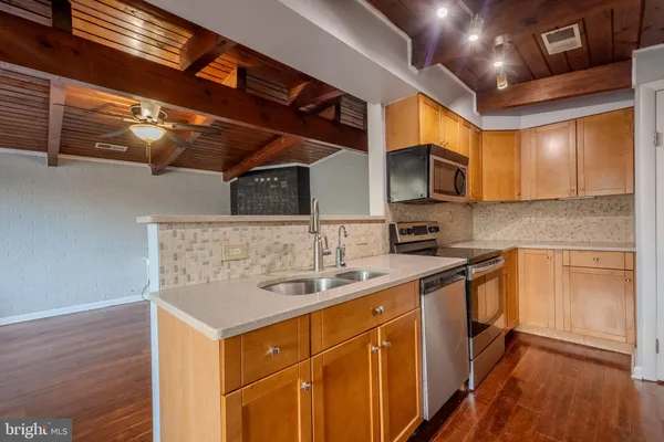 a kitchen with stainless steel appliances granite countertop a sink stove and cabinets