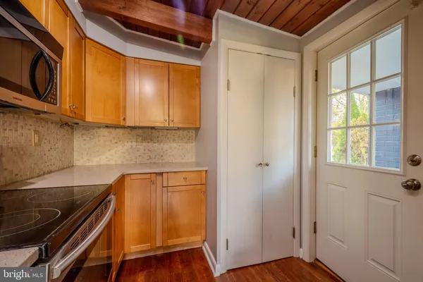 a view of a refrigerator and wooden cabinets