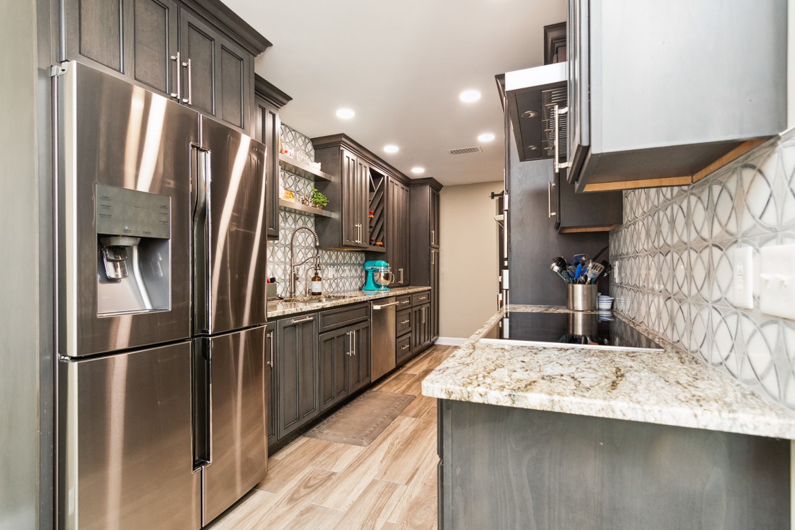 1241 General George Patton Road Nashville, TN 37221 - Photo 7 of 23 a kitchen with stainless steel appliances kitchen island granite countertop a refrigerator a stove and a sink with wooden floor