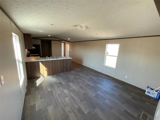 a view of a kitchen with a sink refrigerator and wooden floor
