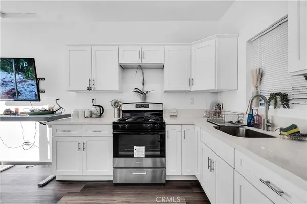 a kitchen with white cabinets and white appliances