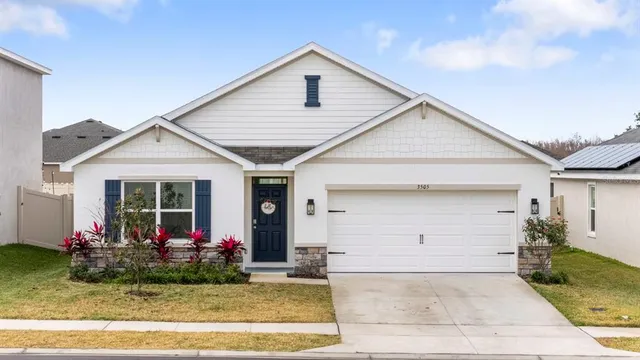 a front view of a house with a yard and potted plants