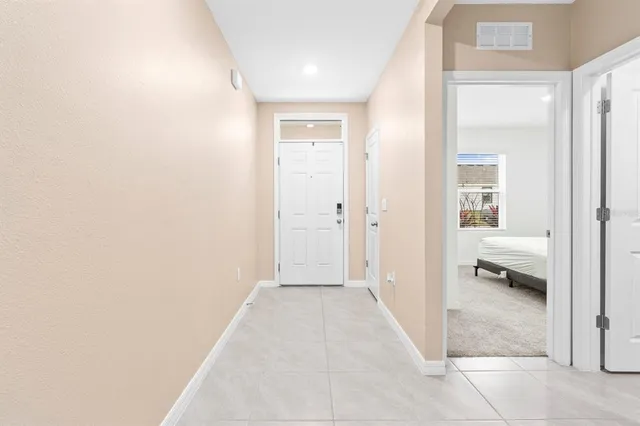 a view of a hallway with a livingroom and a bathroom with a sink