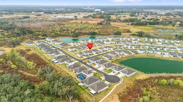a view of a white house with a big yard and large trees