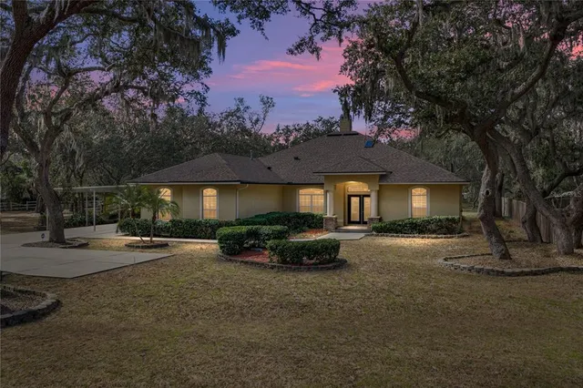a front view of a house with yard and trees