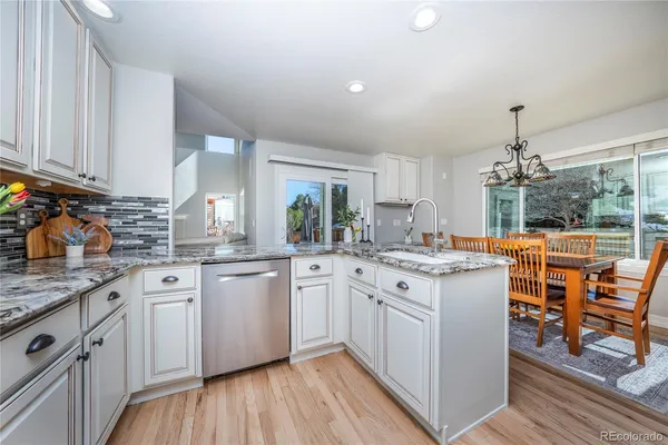 a kitchen with stainless steel appliances granite countertop a refrigerator a stove and a sink