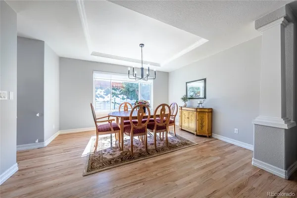 a dining room with furniture a chandelier and wooden floor