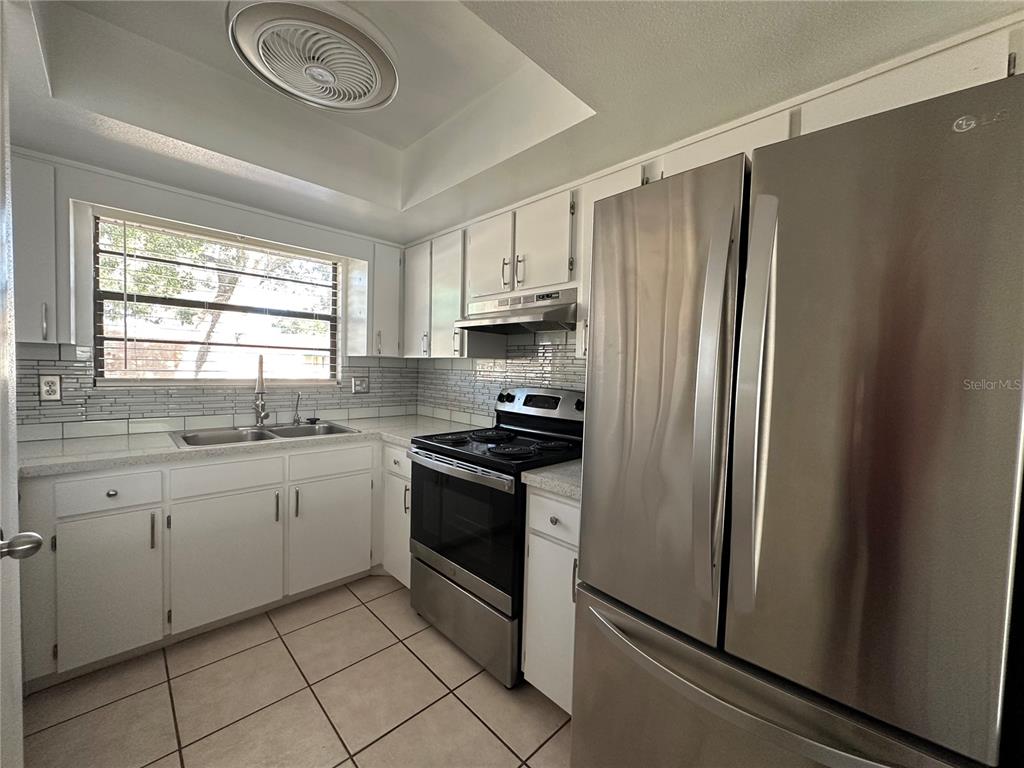 6104 Topher Trail, Unit 6104 Mulberry, FL 33860 - Photo 5 of 19 a kitchen with stainless steel appliances granite countertop a refrigerator sink and stove